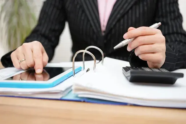 female accountant using assistance on tablet pc to complete work